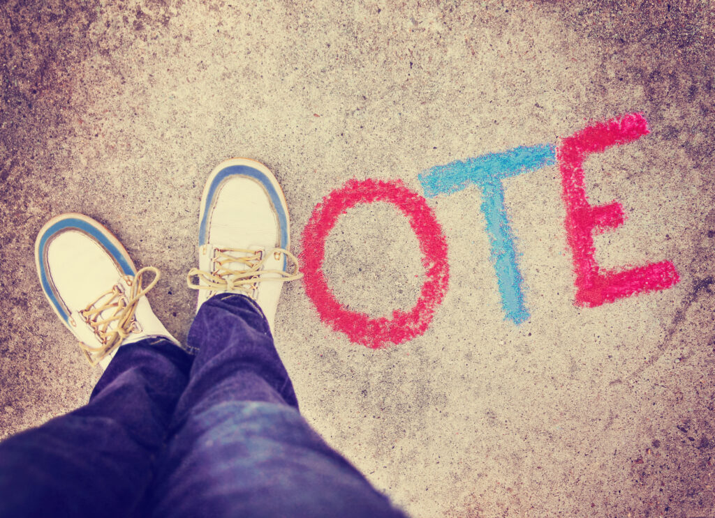 a pair of shoes in the form of the letter V for vote on a sidewalk toned with a retro vintage instagram filter app or action effect