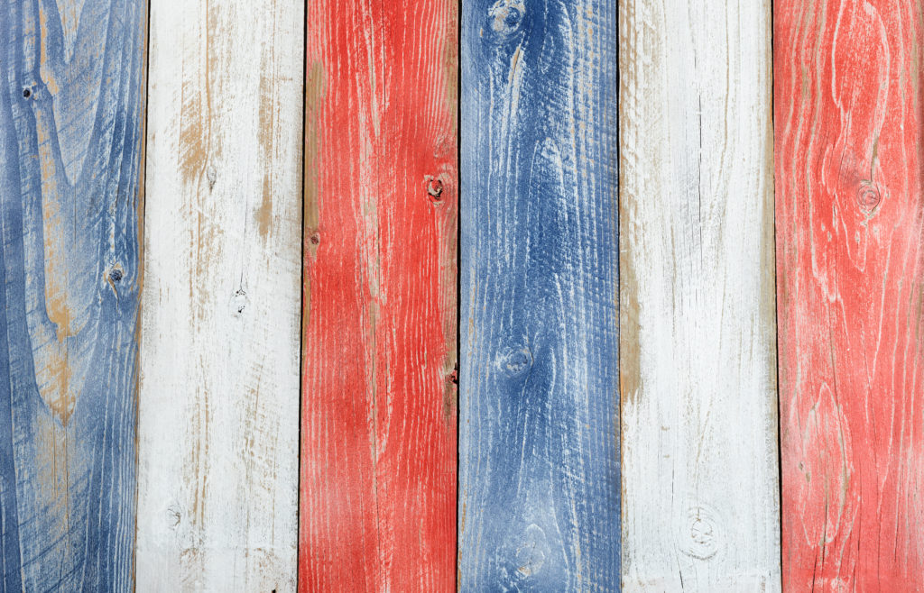 Stressed wooden boards painted red white and blue for patriotic concept of United States of America. Layout in vertical format.