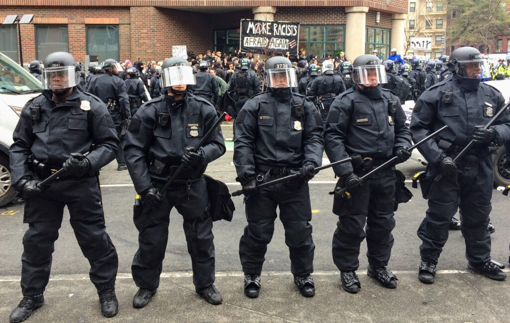 WASHINGTON, Jan. 20, 2017 -- Police in riot gear form a line around detained #DisruptJ20 protesters holding a "Make Racists Afraid Again" banner during the presidential inauguration of Donald Trump.