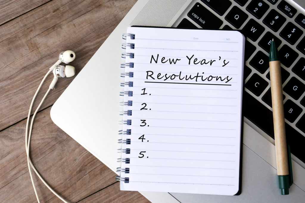 New year's resolutions written on paper on top of laptop keyboard