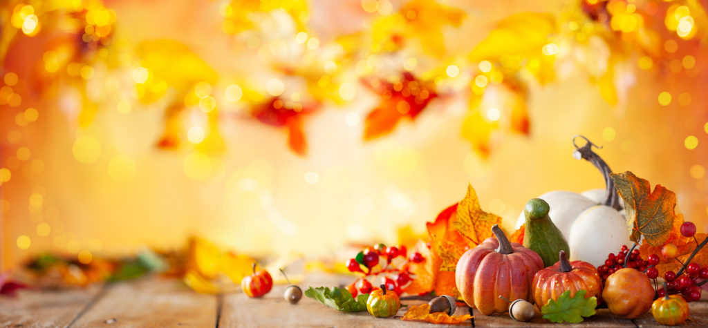 Autumn background from fallen leaves and pumpkins on wooden vintage table. Autumn concept with red-yellow leaves background. Thanksgiving pumpkins.